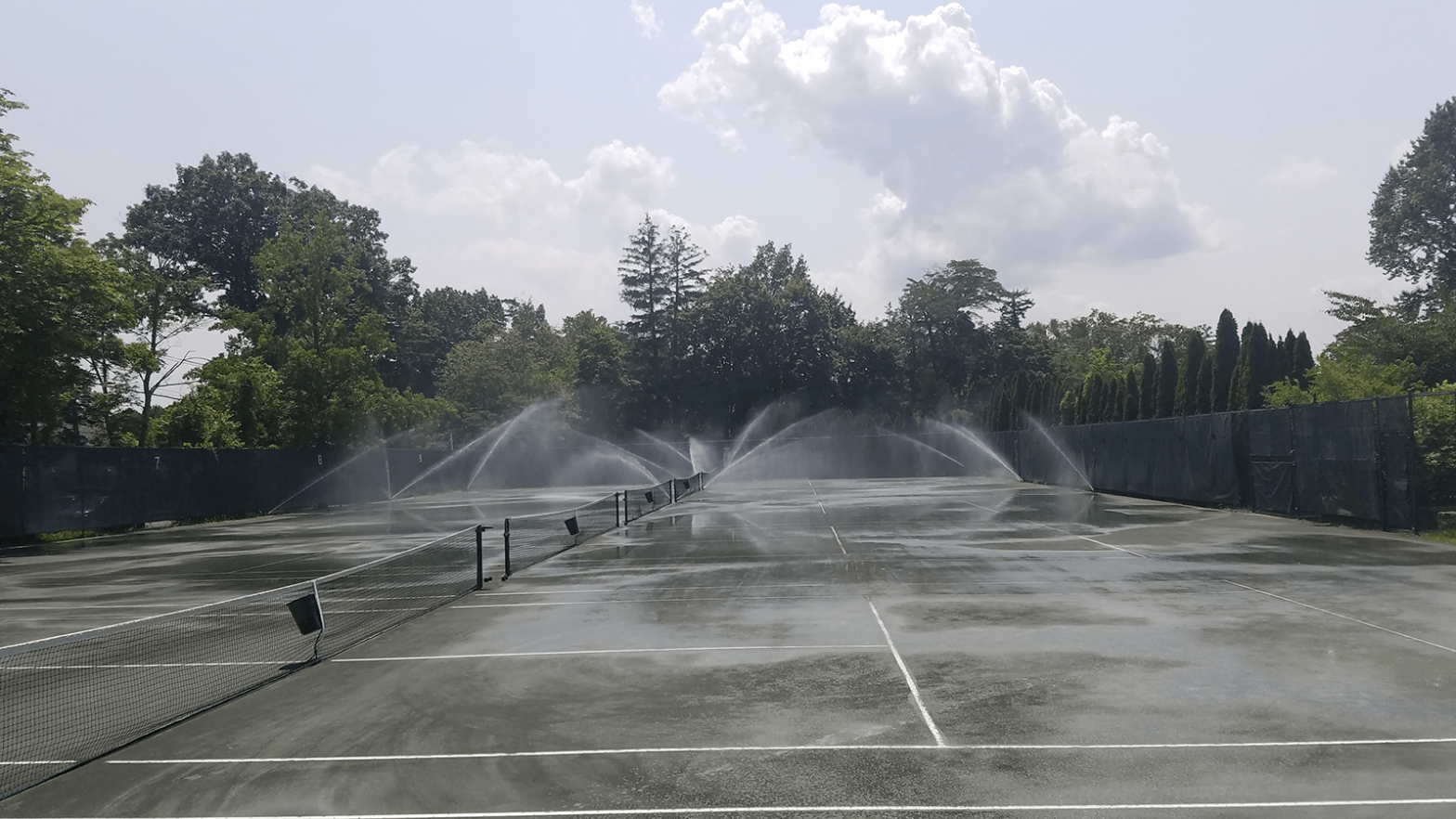 sprinkler on clay tennis courts at Quaker Ridge